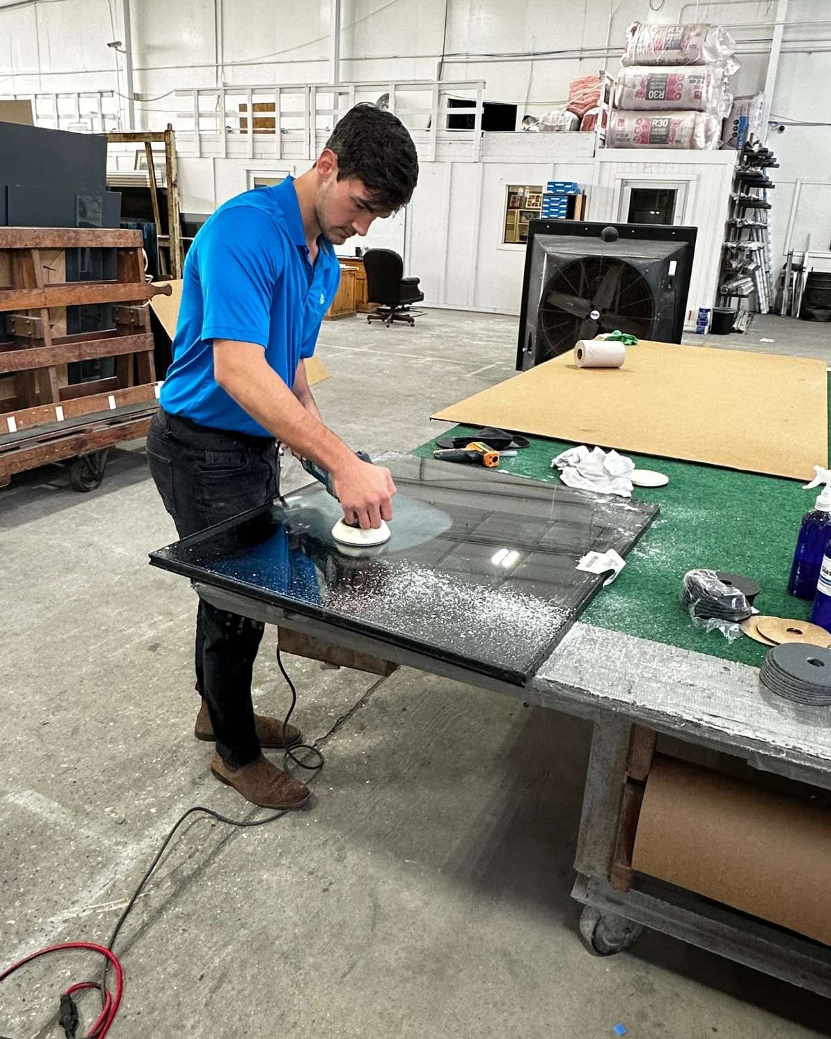 Glass laid out on a shop table being prepared for restoration